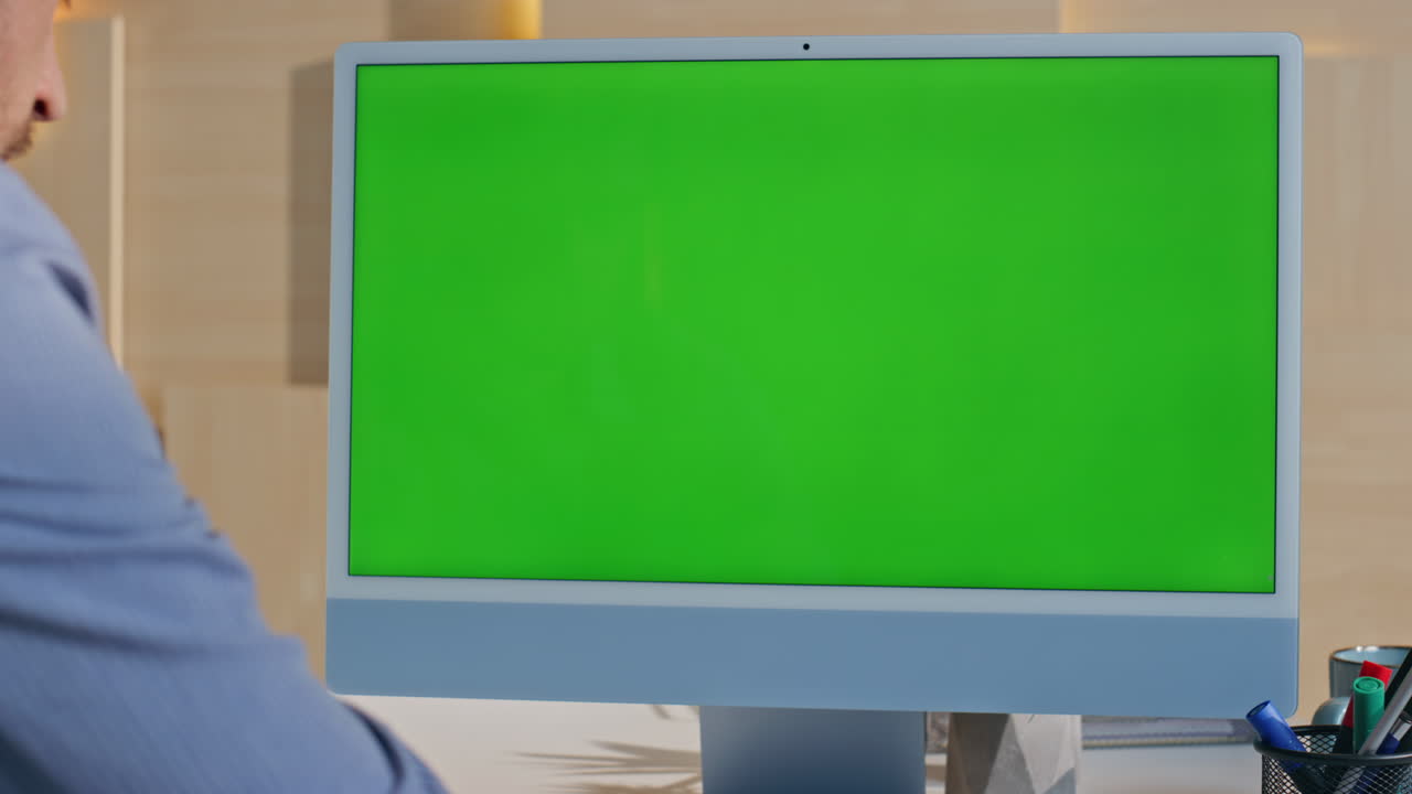Businessman looking greenscreen computer working at office desk close up.