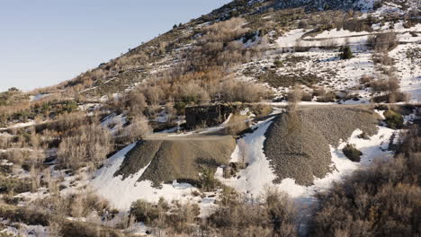 Edificio-Abandonado-En-La-Ladera-De-La-Montaña-Con-Nieve-En-Eureka,-Utah