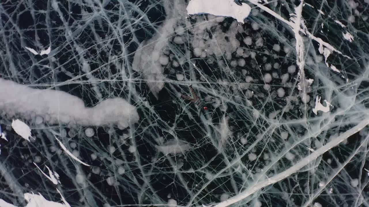 드론은 빙판 위에 누워있는 소녀의 시야와 함께 회전하고 위로 날아갑니다. 겨울에 팔과 다리를 으로 흔들며 천사를 묘사합니다.