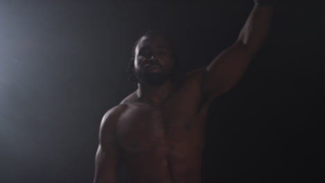 portrait of boxer entering ring before start of boxing match waving and greeting fans warming up and sparring with low key lighting