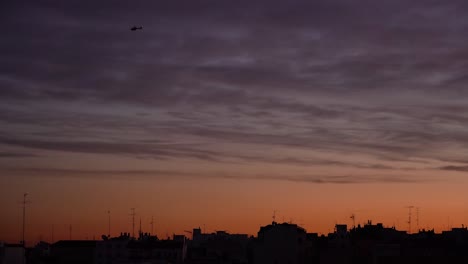 Helicóptero-Contra-El-Colorido-Cielo-Del-Atardecer-Sobre-La-Ciudad