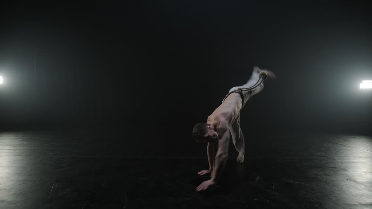 Lottatori di Capoeira che eseguono mosse dinamiche sul palco. Arti marziali, danza e acrobazie in azione. Atleti a torso nudo che mostrano forza, flessibilità e tecnica sotto i riflettori