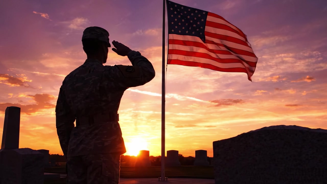 Un soldato che saluta la bandiera al crepuscolo: un tributo al sacrificio e all'onore con la bandiera americana che sventola fieramente contro un cielo vibrante al tramonto