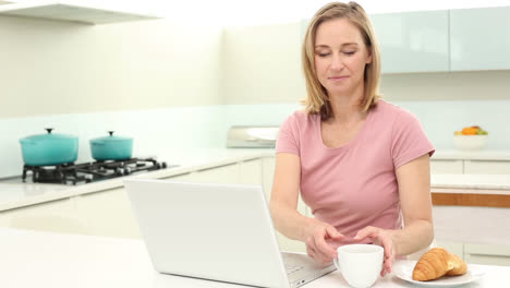 Mujer-Madura-Tomando-Café-En-El-Desayuno-Usando-Su-Computadora-Portátil