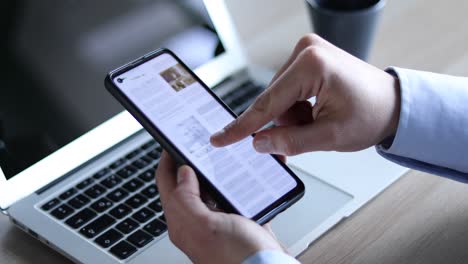 hombre de negocios leyendo el periódico en la pantalla de su teléfono inteligente