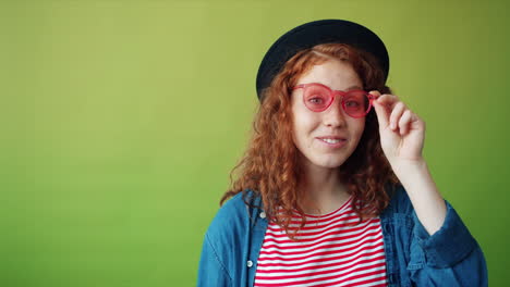 smiling woman with red sunglasses and hat