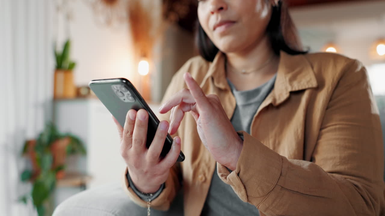 mujer usando el teléfono mientras está sentada en un sofá