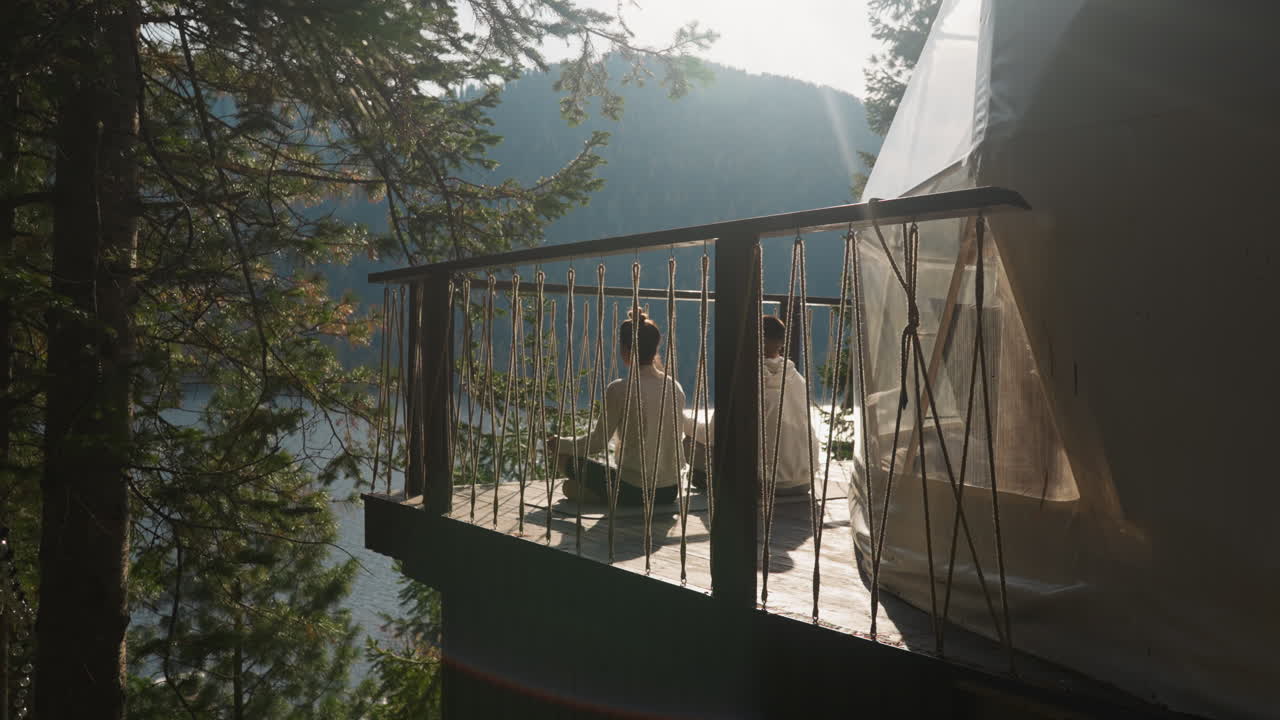 Lovers of yoga connect with nature at gambling. Couple embraces sunrise meditation practice attuning to gentle serenity of morning. Spiritual growth