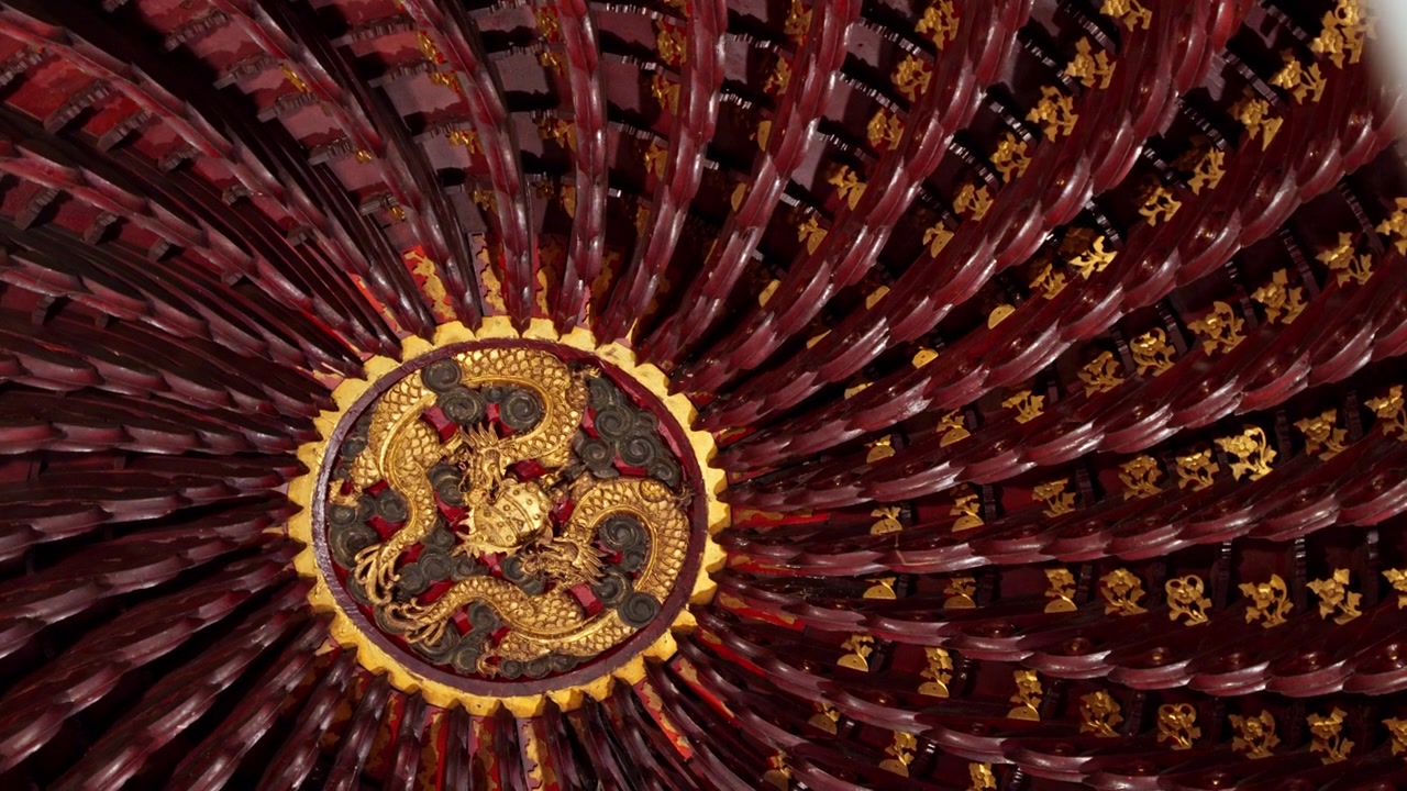 Una vista dettagliata di un medaglione di drago dorato su uno sfondo di soffitto riccamente decorato. Ideale per documentari culturali o elementi architettonici