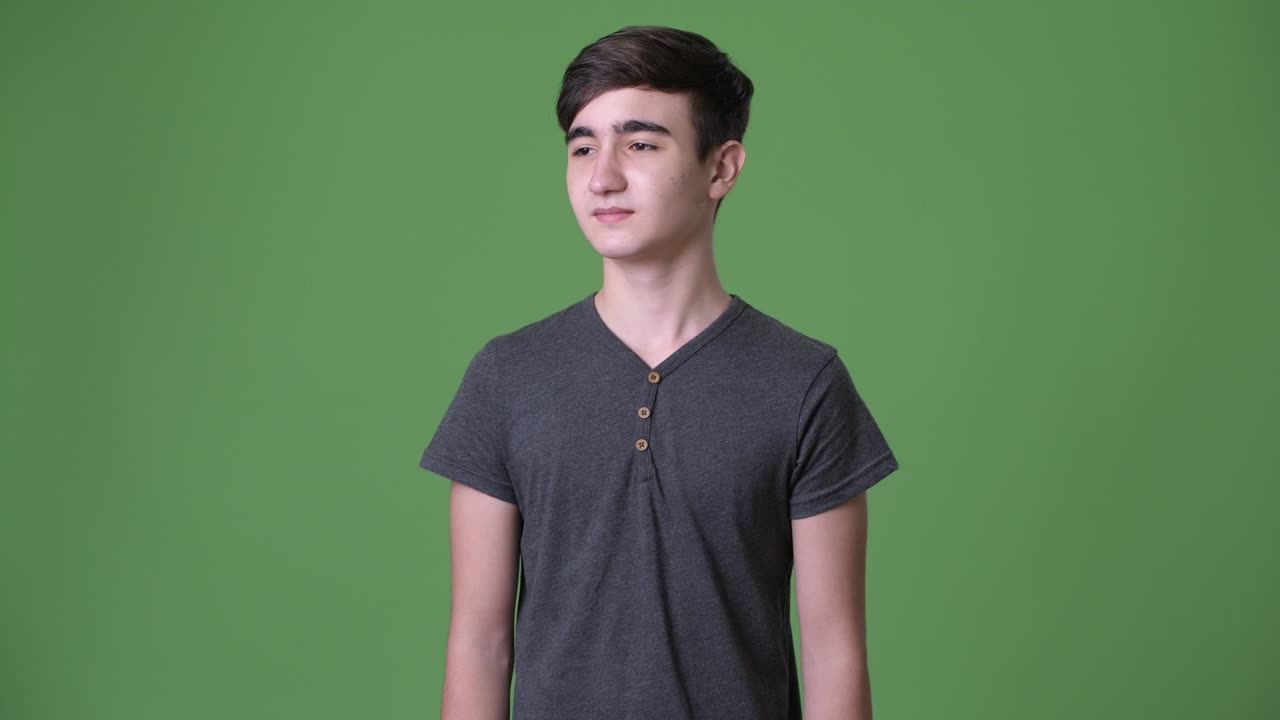 초록색 배경에 젊은 잘생긴 이란 십대 소년