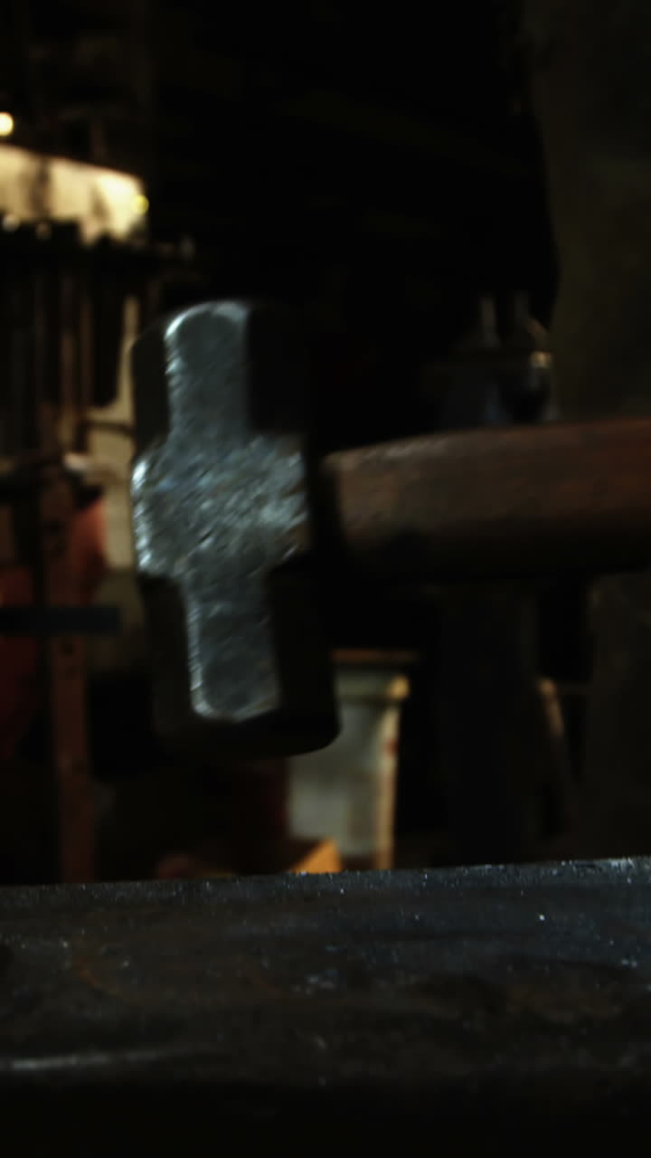 Mid-section of blacksmith holding hammer