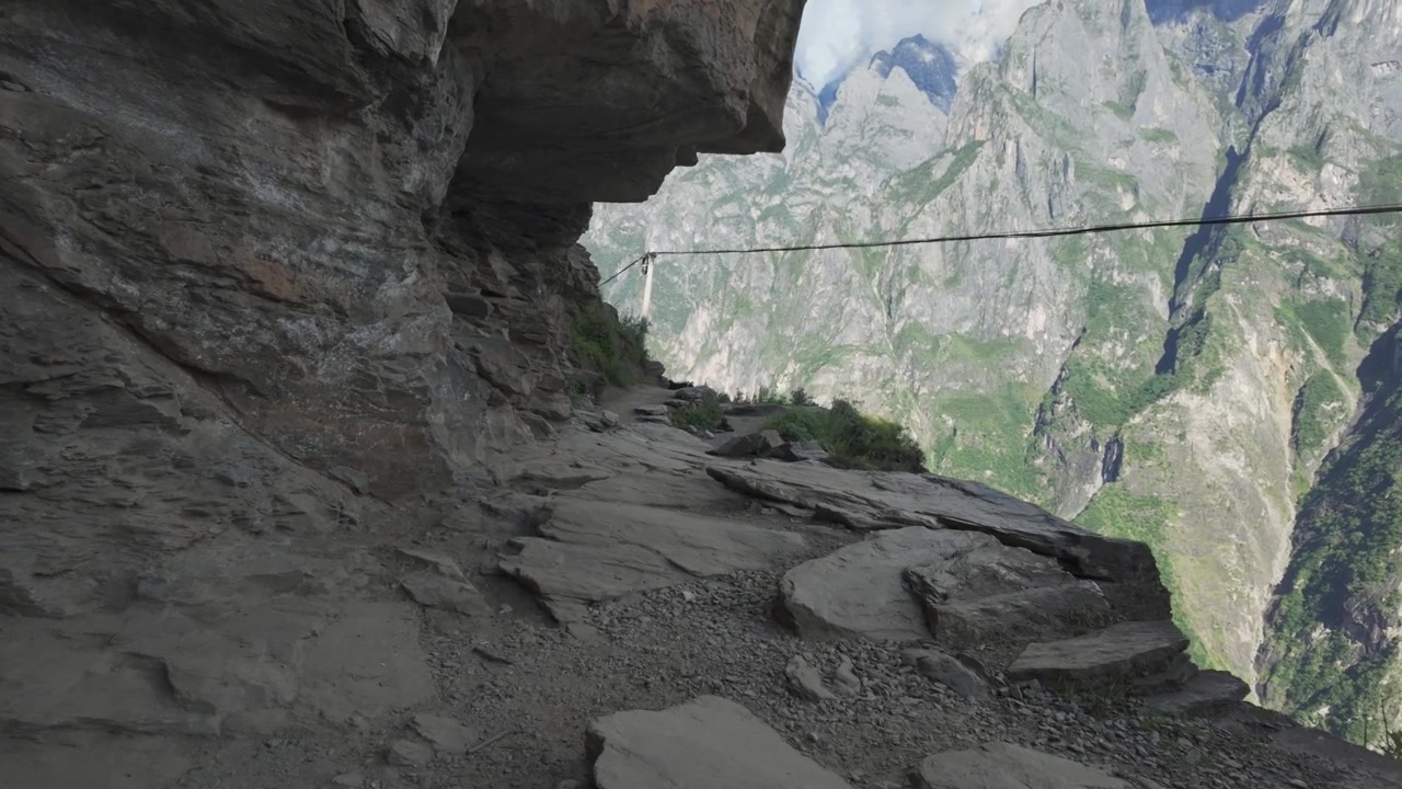 Dramatisk POV-opptak som går langs den smale stien langs klippesiden høyt oppe i Tiger Leaping Gorge i Yunnan, Kina. Perfekt for reisedokumentarer og eventyrfortellinger