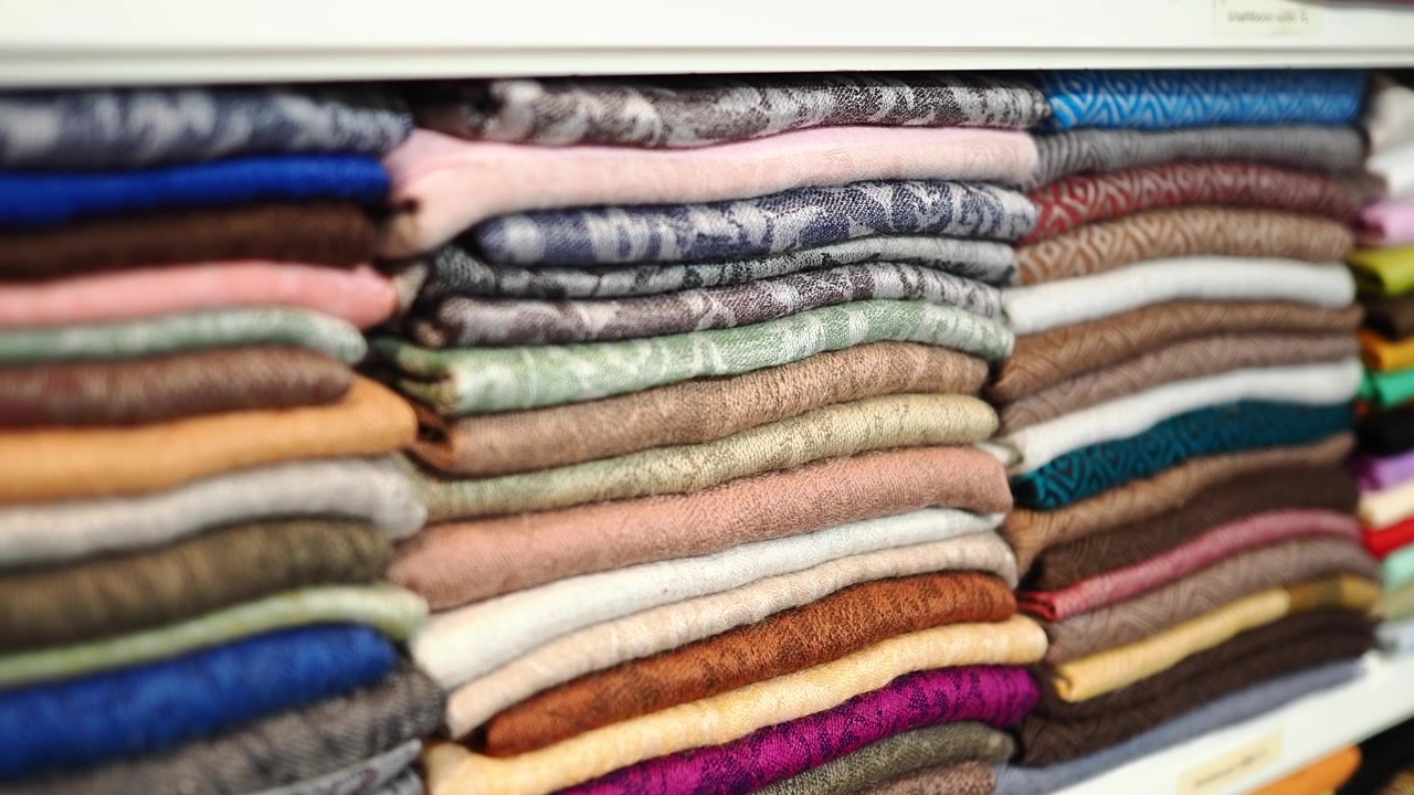 Close-up of Neatly Stacked Colorful Textiles on Shelves