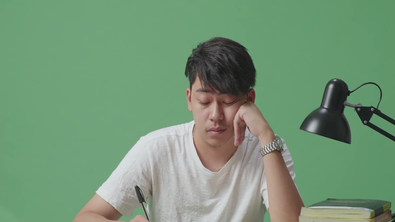 지친 학생이 공부하고 있습니다.