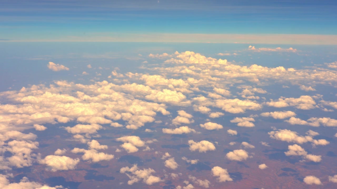 Splendida prospettiva dal finestrino di un aereo che vola in alto sopra una magnifica coltre di nuvole cumulo bianche che fluttuano sull'Africa orientale in una giornata limpida e soleggiata
