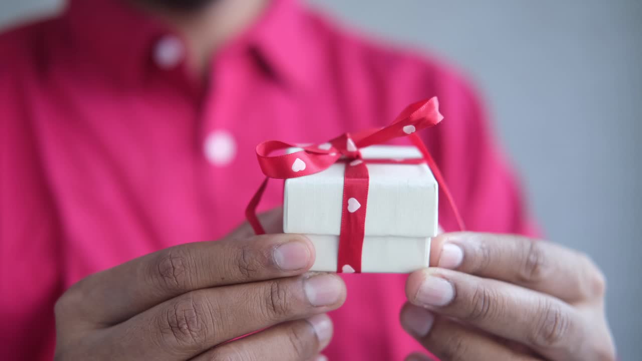 작은 선물 상자를 들고 있는 남자