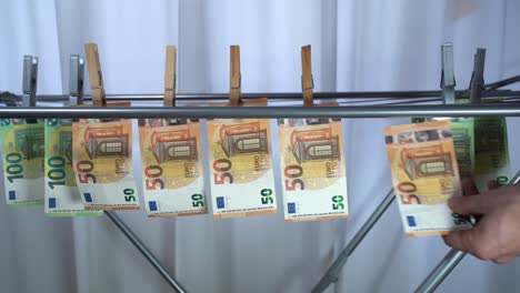 money hanging to dry with clothespin - euro money banknotes after  washing machine - illegal cash 50, 100 €  and mafia money laundering - increase in the cost of living, energy and gas