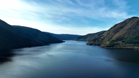 Morning-aerial-Above-Sorfjorden-with-Osteroy-bridge-seen-in-background,-Autumn-blue-sky