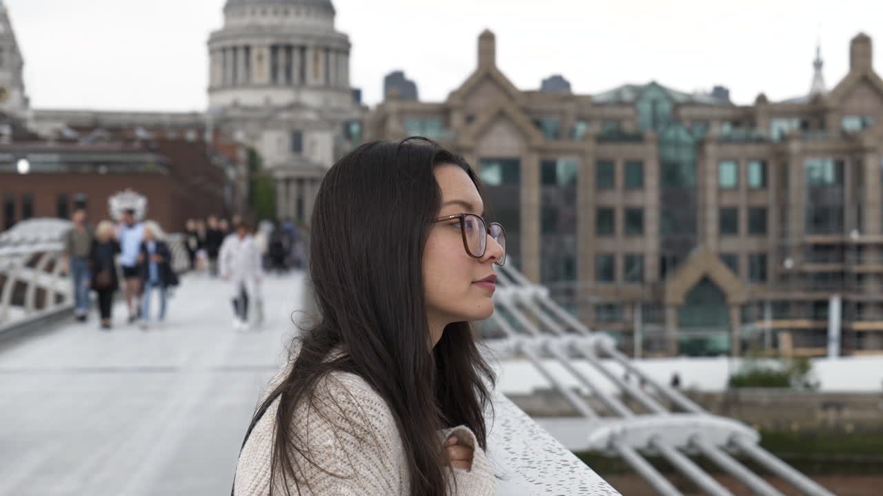 mujer joven mirando el río támesis desde el puente del milenio con la catedral de san pablo al fondo