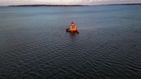 An-aerial-view-of-the-Huntington-Harbor-Lighthouse-on-Long-Island,-NY-at-sunset,-with-a-Christmas-wreath