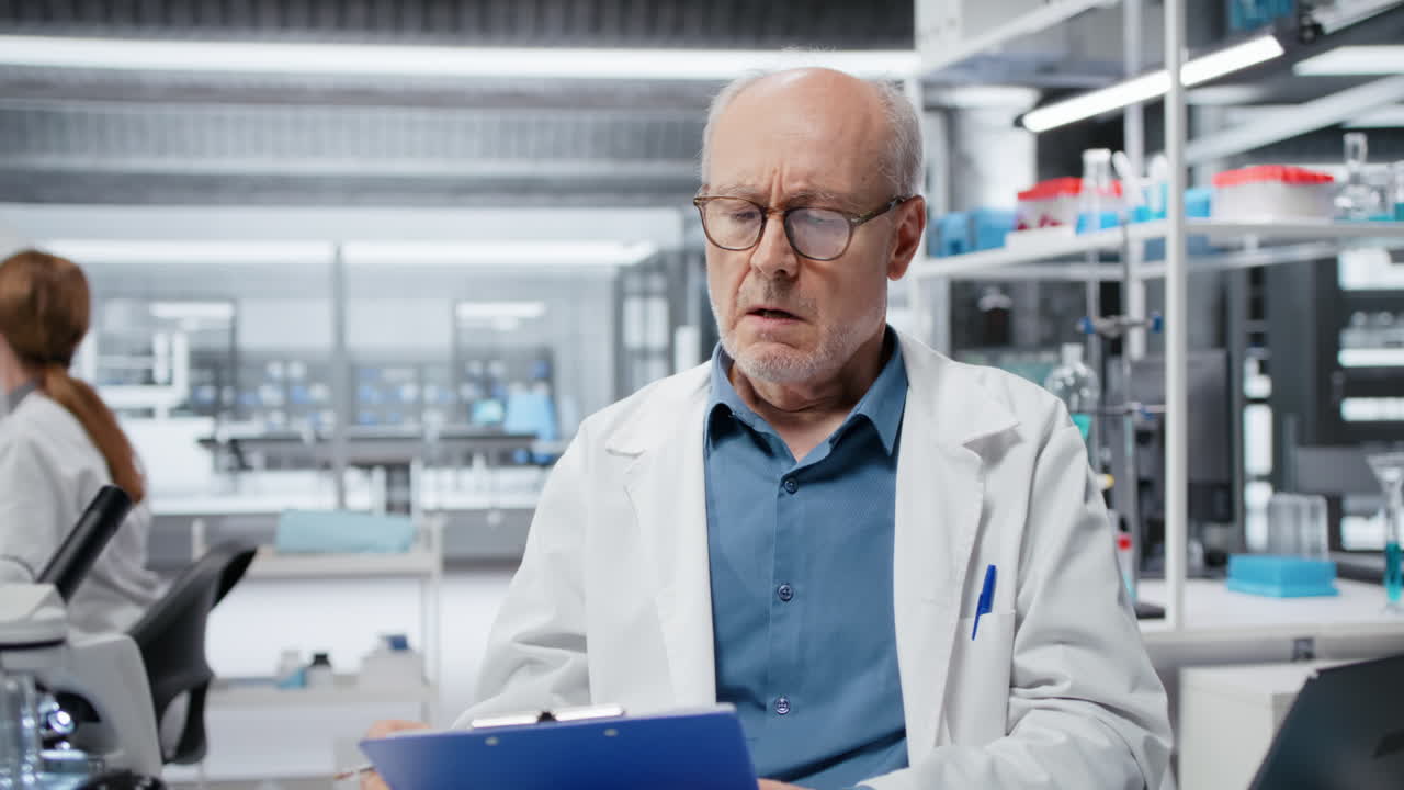 Profissional sênior de laboratório conduzindo pesquisa, fazendo anotações