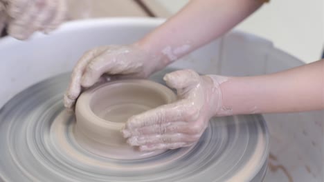 the master potter teaches the child to work with clay on a potter's wheel.