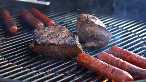 steaks and hotdogs sizzling as they grill on the barbecue