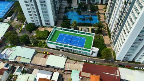 drone shot of ho chi minh city, saigon, vietnam. features condo apartments and a tennis court. captures urban living and recreational facilities.