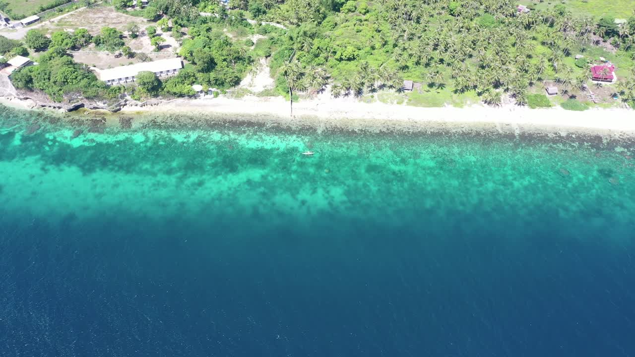 toma aérea de arriba hacia abajo del océano azul profundo y la costa turquesa transparente durante el día soleado en filipinas