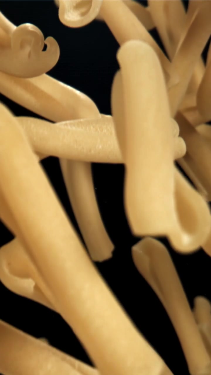 Pasta cruda che cade al rallentatore su sfondo nero