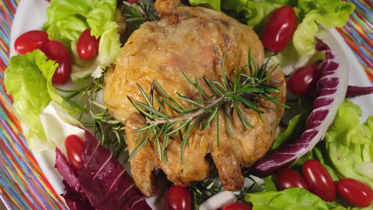 Baked chicken with salad and tomato vegetables rotating on dish