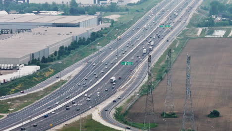 aerial view of the busy 401 highway running alongside a farm field in milton, ontario