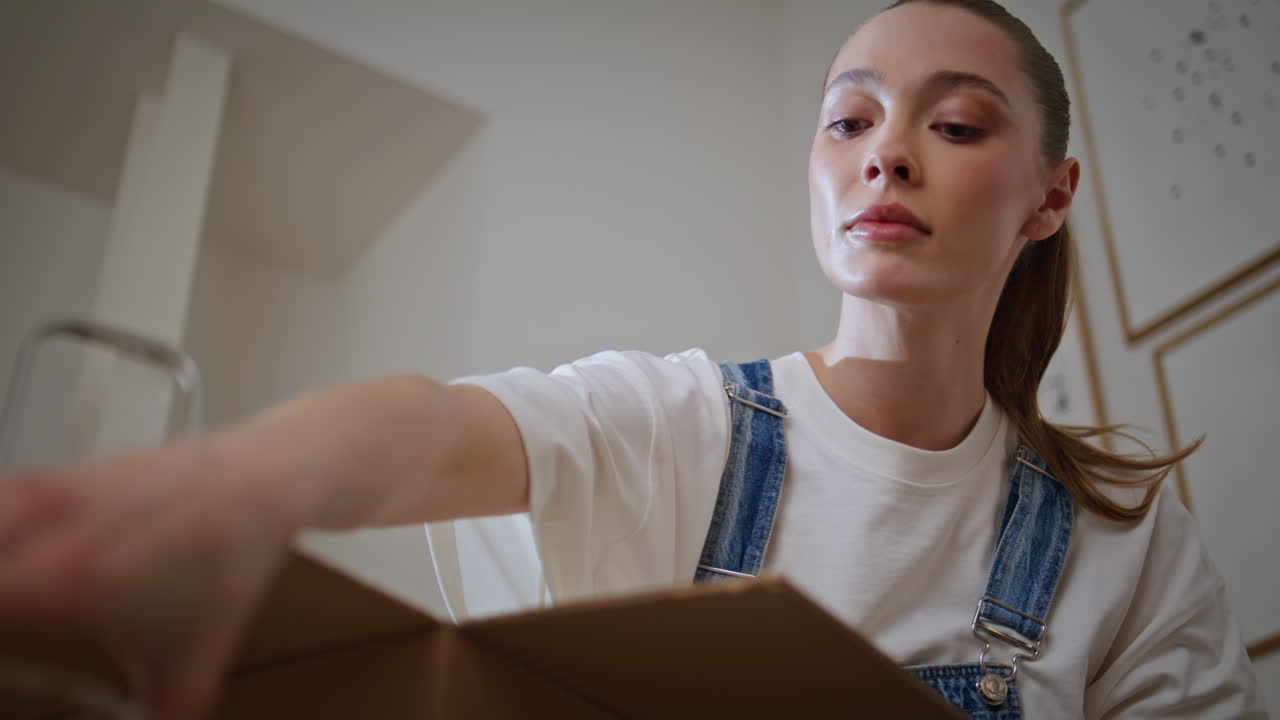 Woman unboxing household items moving in new apartment closeup. Lady unpacking