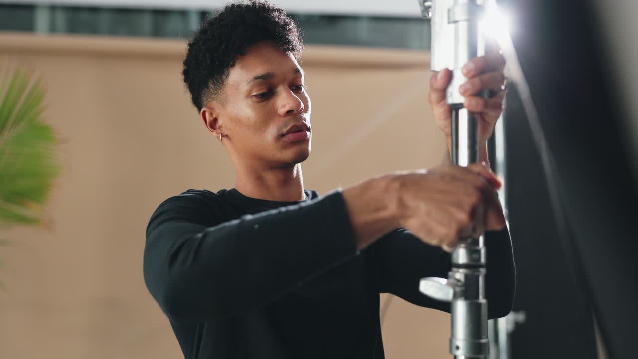 Photographer Adjusting Studio Lighting Equipment