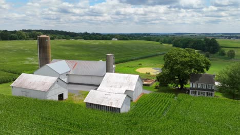 hiperlapso aéreo de una granja familiar en los estados unidos rurales rodeada de campos de maíz en verano