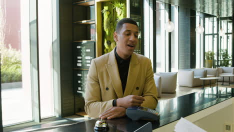 african american man leaning on the counter of a hotel