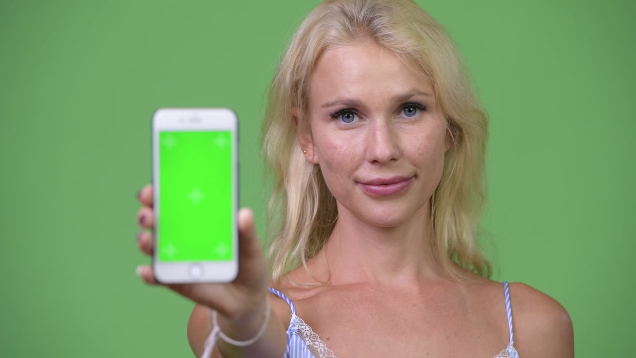 Young happy beautiful businesswoman showing phone