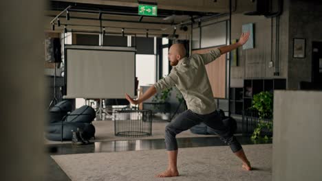 man practicing yoga in an office