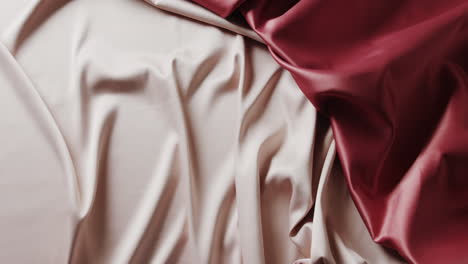 close-up van witte en rode glanzende zijden kleren in slow motion met kopieerruimte.