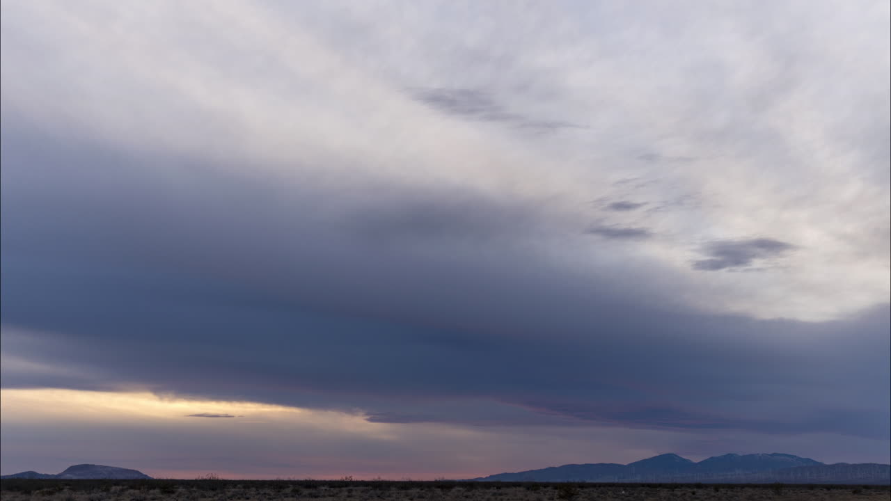 숨막히는 붉은 색과 오렌지색 일출이 흐린 보라색 하늘을 비추고 시간 경과