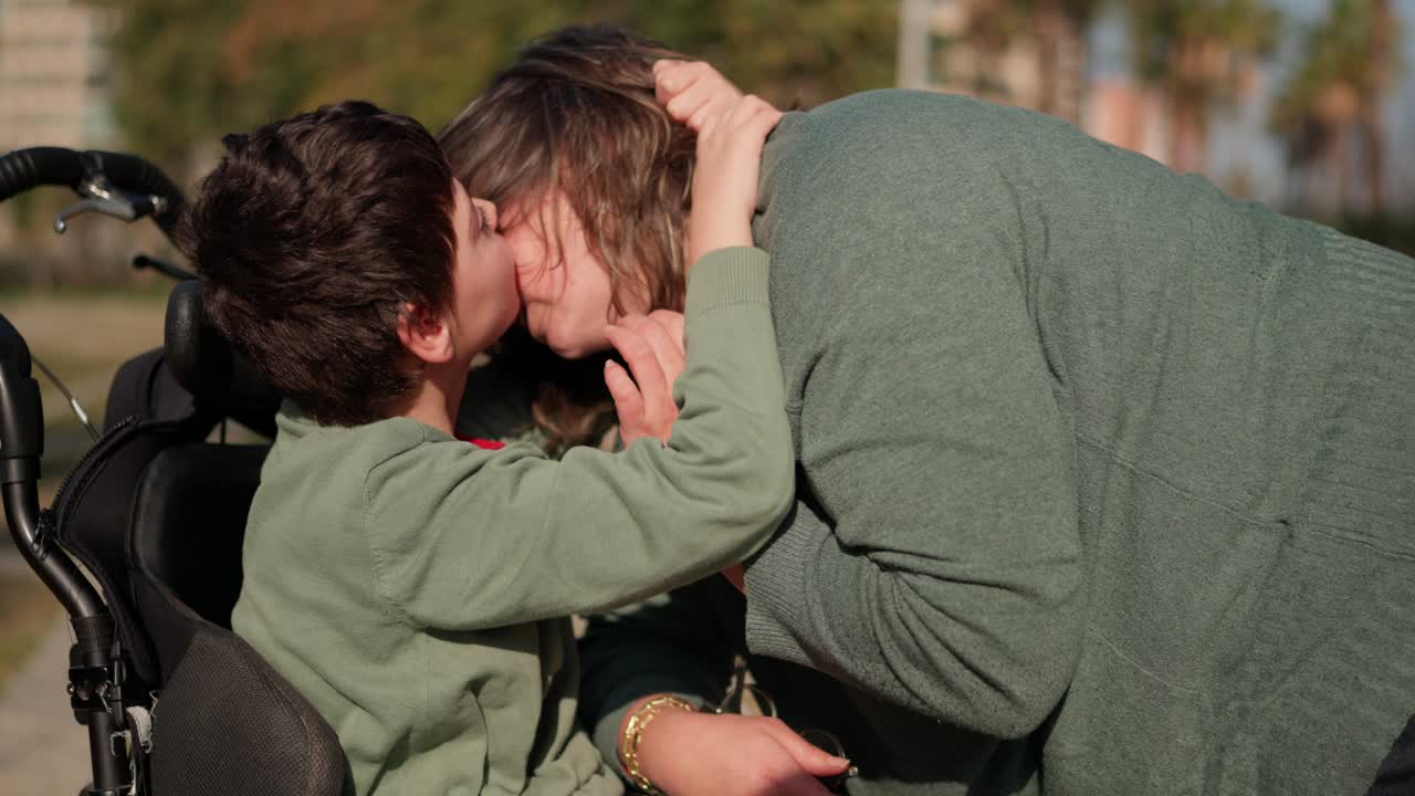 Loving Family Moment: Child Kisses Parent in Wheelchair