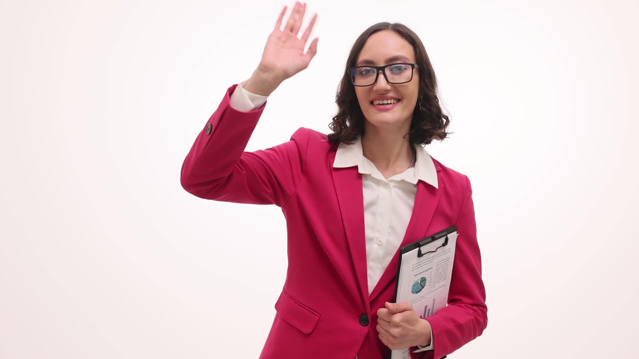 Donna d'affari professionista che saluta con la mano con grafici su un blocco appunti