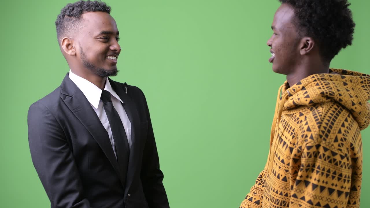 Giovane uomo d'affari africano e giovane uomo africano insieme su sfondo verde