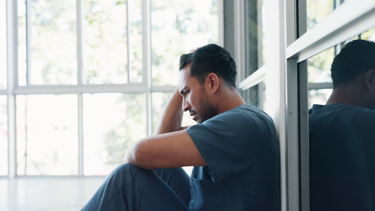 Nurse, stress or depression man on hospital floor
