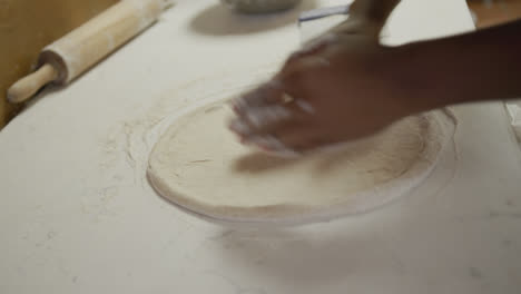 hombre de raza mixta haciendo una masa de pizza