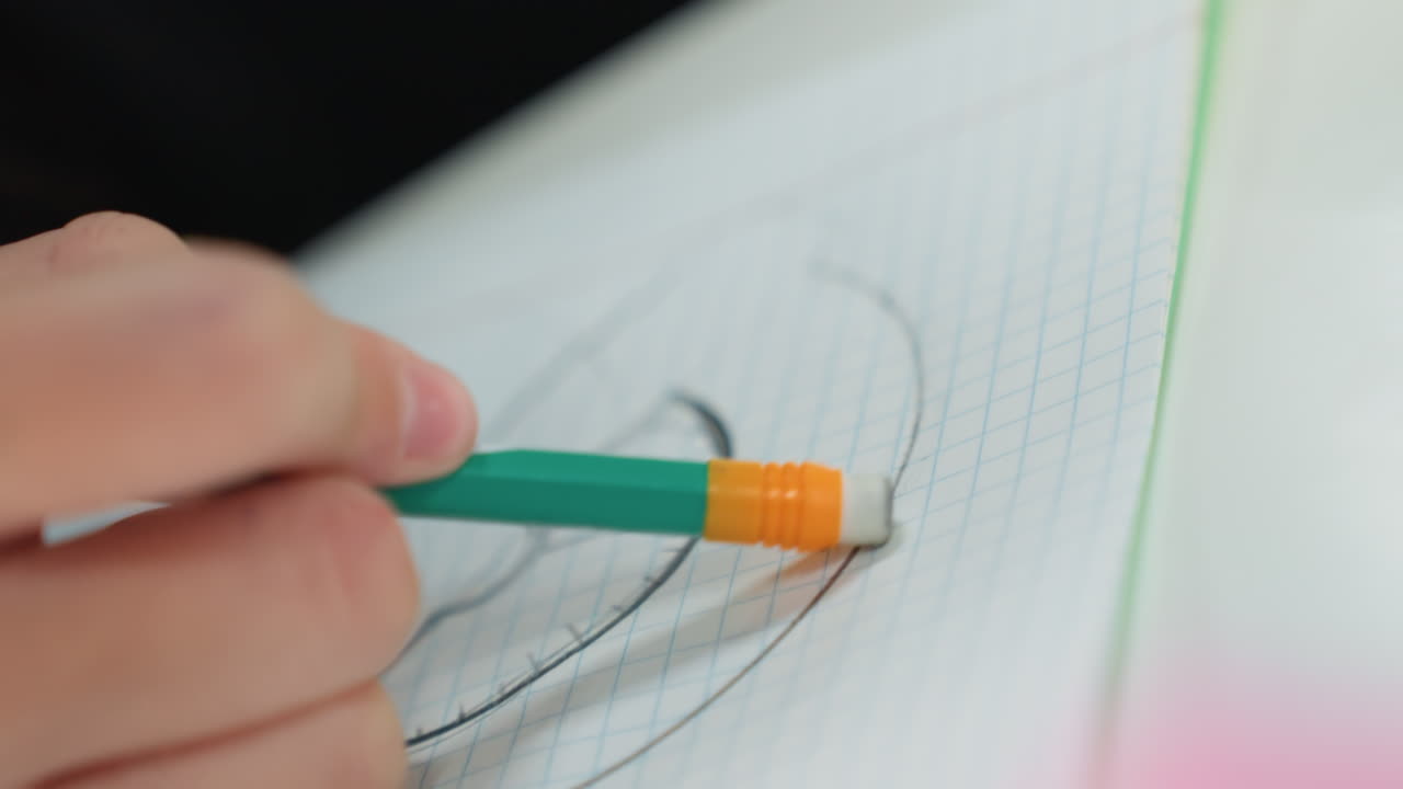Primo piano di uno studente di architettura che cancella una linea curva su un foglio a griglia; la mano usa una matita con gommino per rimuovere la grafite e rifinire il contorno; lo sfondo leggermente sfocato e l'illuminazione da studio enfatizzano la precisione.