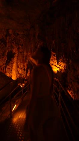 woman exploring illuminated cave
