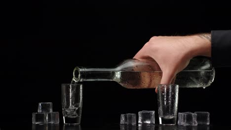 two hands reaching for shot glasses of vodka with ice