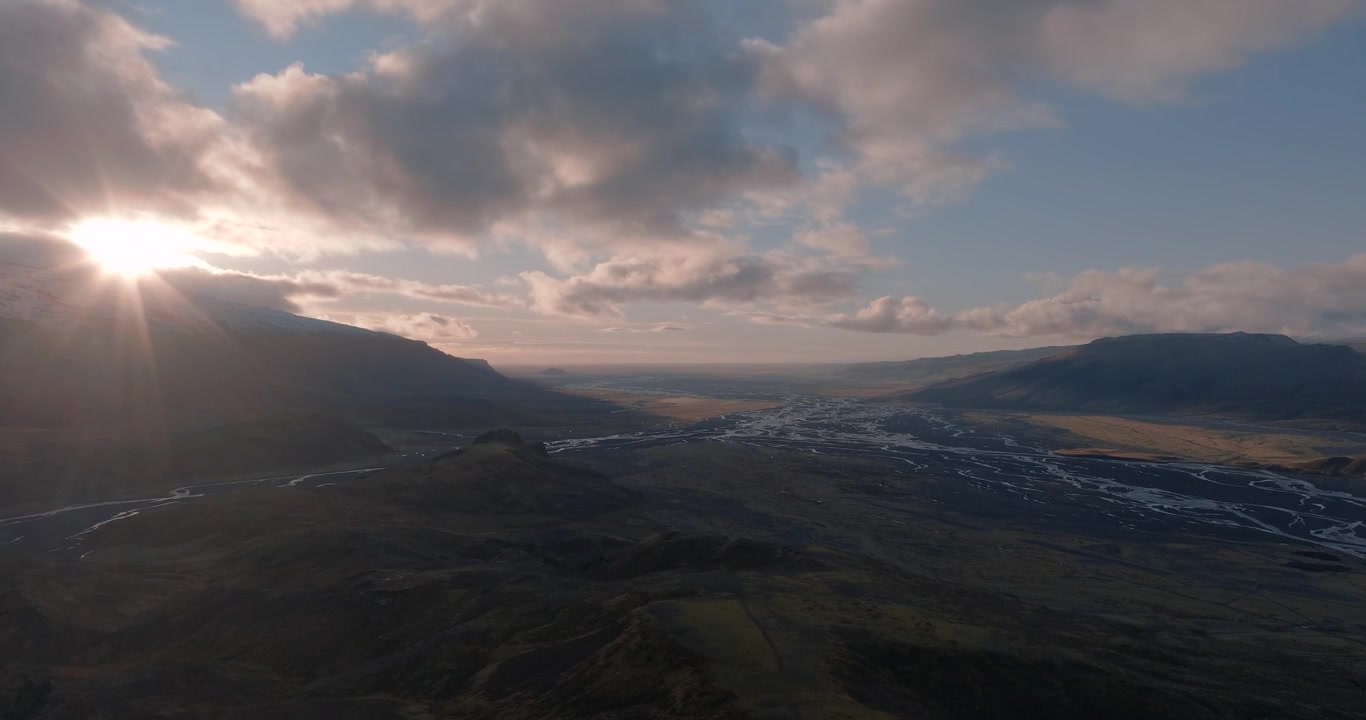 Fiume Krossa e pianura alluvionale di Markarfljot a Thorsmork, Islanda meridionale, circondati da altipiani vulcanici, canali glaciali intrecciati e montagne distanti durante il tramonto, ripresa aerea di rivelazione.