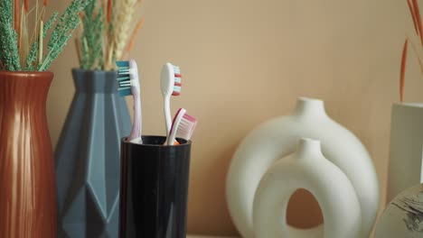 toothbrushes in a holder with decorative vases